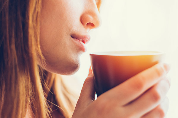 woman drinking coffee after Microneedling in La Jolla