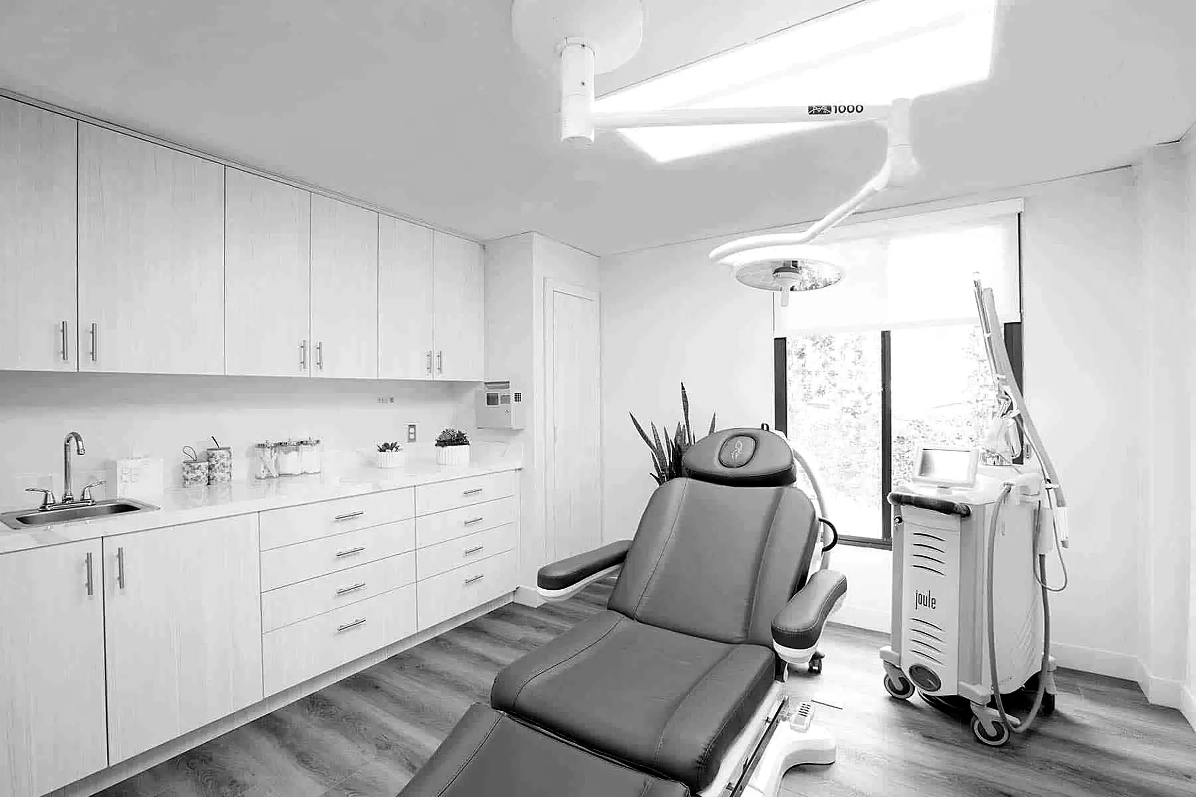Treatment room with an exam chair and laser cart at La Jolla Laser Derm in La Jolla, CA